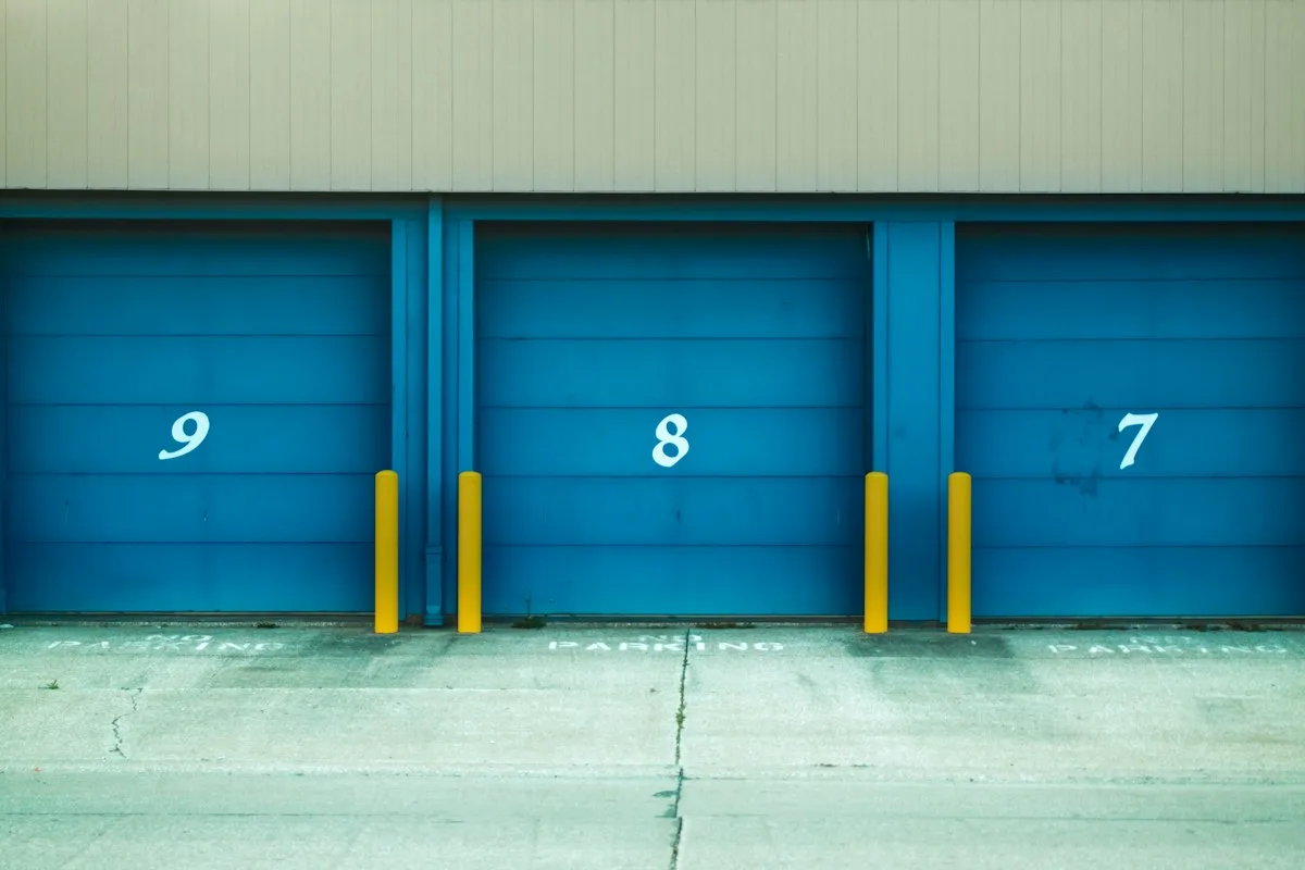 Three numbered roll-up doors on the bays of a commercial building