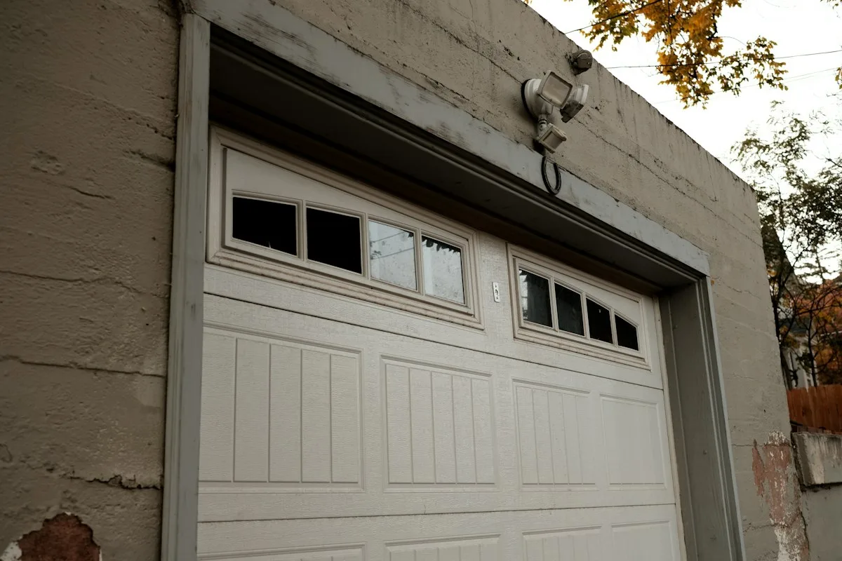 White steel sectional overhead garage door on a brick building