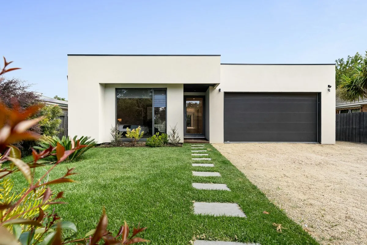 White house with a closed black garage door