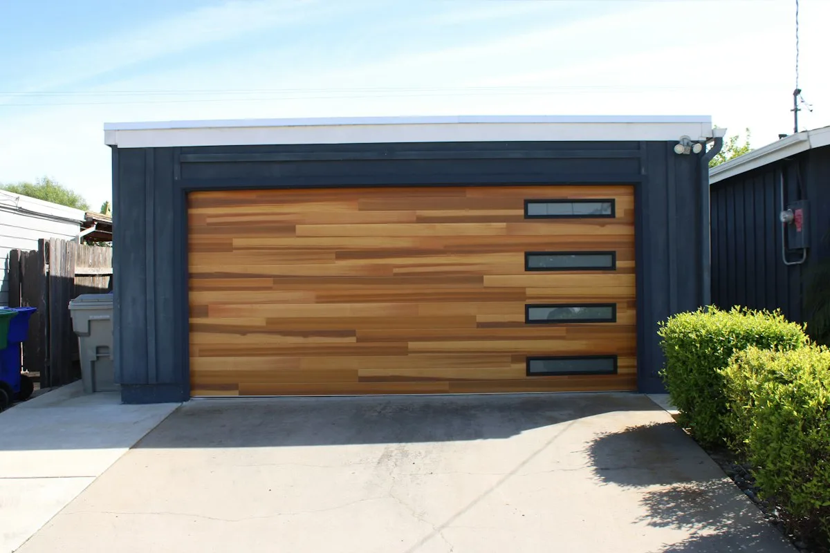 Modern garage door with wood panels and window inserts